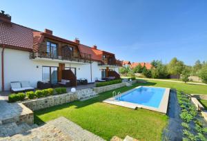 a house with a swimming pool in a yard at Apartamenty Pod Łysicą & SPA - przy stoku, basen, jacuzzi, sauna in Krajno Pierwsze