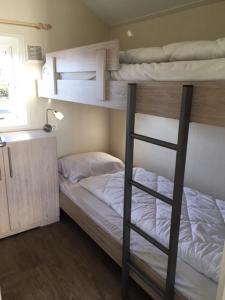 a bedroom with two bunk beds in a room at Camping Oase, Zanddijk 75 in Julianadorp