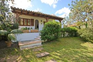 ein kleines Haus mit einer Veranda und einem Hof in der Unterkunft Villa Spiros in Alcúdia