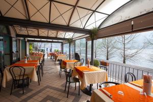 a restaurant with tables and chairs and a balcony at Appartamento "La Collina" in Monte Isola