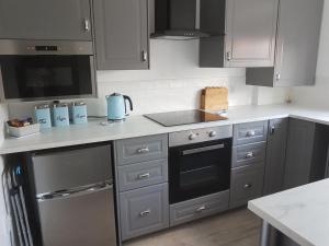 a kitchen with gray cabinets and a stove top oven at 1, The Mews in Derby