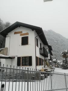 una casa bianca con una recinzione nella neve di Residence Mezzosole a Riva del Garda