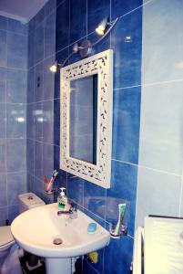 Baño de azulejos azules con lavabo y espejo en Vrachos kai Elia en Pyrgadikia