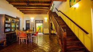 a dining room with a table and a yellow wall at South Point Abbey in Ahangama