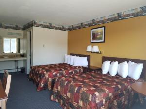 a hotel room with two beds and a table at Clark's Beach Motel in Old Forge +37 photos