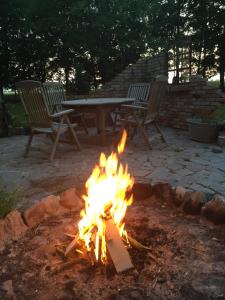 a fire pit with two chairs and a picnic table at Gartenidyll Insel Rügen Poppelvitz bei Altefähr in Altefähr