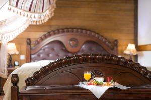 a bed with a tray of food and a glass of orange juice at Zámek Lužec Spa & Wellness Resort in Karlovy Vary