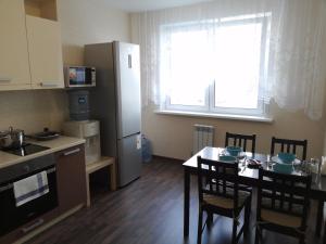 ノヴォシビルスクにあるApartment Finika4 on Frunze 49/1のキッチン(テーブル、椅子、冷蔵庫付)