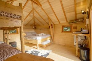 a bedroom in a wooden cabin with a bed at Les Jardins de Coët-Kra in Plaudren