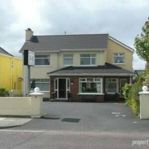 a house with a parking lot in front of it at Aaranmore Lodge Guest House in Portrush