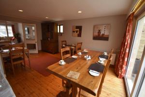 comedor con mesa de madera y sillas en Aaranmore Lodge Guest House, en Portrush