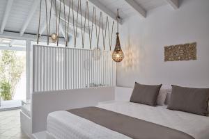 a white bedroom with a bed and a chandelier at Mr and Mrs White Corfu Couples Retreat Adults Only in Acharavi