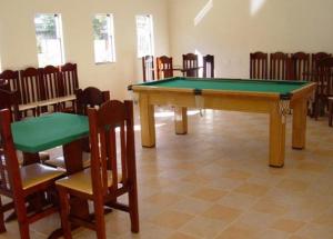 eine Tischtennisplatte in einem Zimmer mit Stühlen in der Unterkunft Hotel Portal de Barequeçaba in Barequeçaba
