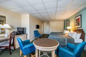 a hotel room with a bed and blue chairs at Days Inn by Wyndham Atlantic City Oceanfront-Boardwalk in Atlantic City