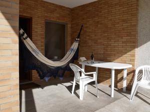 a patio with a hammock and a table and chairs at Casa Casais in Fão