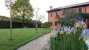 un jardín con flores azules y amarillas y un edificio en Il Farfasole, en Vigonovo