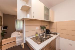 a kitchen with white cabinets and a sink at Apartments Donat in Zadar