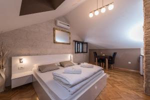 Cama blanca grande en habitación con mesa en Apartments Donat, en Zadar