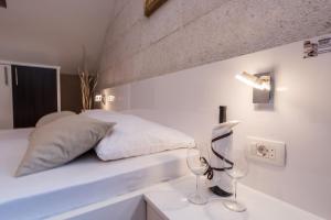 a white bedroom with a bed and a lamp on a counter at Apartments Donat in Zadar