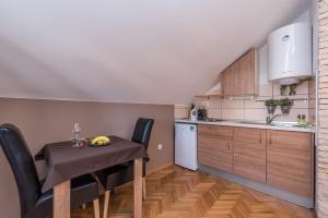 a small kitchen with a table and chairs in a room at Apartments Donat in Zadar