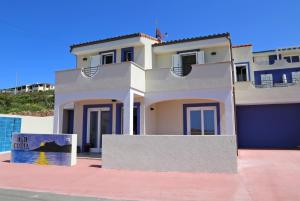 卡斯特尔萨多B&B COSTA的一座白色的房子，前面有一块牌子