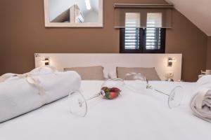 a bed with glasses and a bowl of strawberries on it at Apartments Donat in Zadar