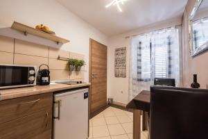 a small kitchen with a table and a microwave at Apartments Donat in Zadar