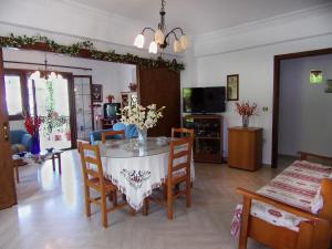 a living room with a table with chairs and a tv at Vaso's Bay House in Yenion