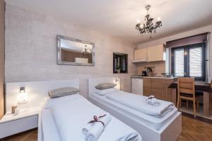 two beds in a room with a kitchen and a mirror at Apartments Donat in Zadar