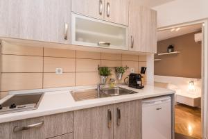 a kitchen with wooden cabinets and a sink at Apartments Donat in Zadar