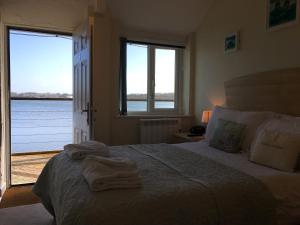 1 dormitorio con 1 cama grande y toallas. en The Old Quay House en Hayle