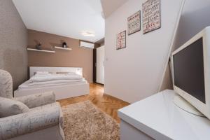 a living room with a bed and a television at Apartments Donat in Zadar