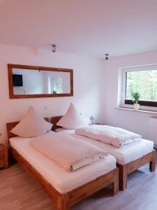 2 camas en una habitación blanca con espejo en Hanse Hotel Buxtehude en Buxtehude