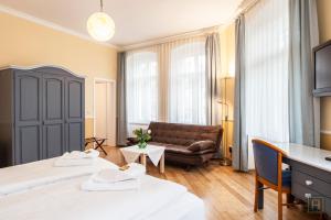 a hotel room with two beds and a couch at Hotel Silesia in Görlitz