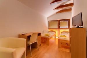 Habitación con 2 camas, mesa y TV. en 101 PENZION, en Prešov