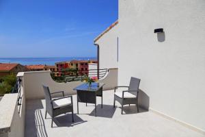 patio con mesa y sillas en el balcón en B&B COSTA, en Castelsardo