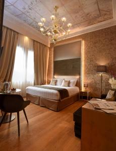 a bedroom with a large bed and a chandelier at Santa Croce Boutique Hotel in Venice