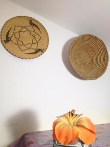 two straw hats on a wall next to a pumpkin at Casa VeroSol in Castelsardo
