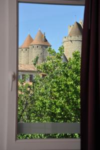 a view of a castle from a window at Hotel Espace Cite in Carcassonne