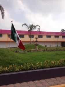 a flag in front of a building with a fountain at Hotel & Villas 7 in Mexico City