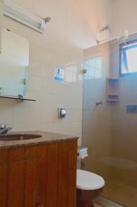 een badkamer met een wastafel, een toilet en een spiegel bij Cabo Frio Fun Hostel in Cabo Frio