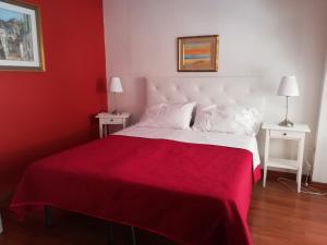 Dormitorio rojo con cama blanca y manta roja en Matera nel Cuore, en Matera