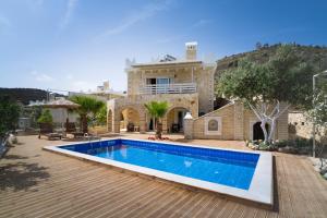 a villa with a swimming pool in front of a house at Aristidis country villa-anesis in Kamilari