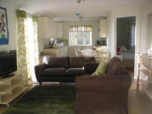 a living room with a couch and a kitchen at Cools Farm B&B + Cottages in East Knoyle