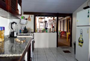 a kitchen with a counter top and a refrigerator at Cabo Frio Fun Hostel in Cabo Frio