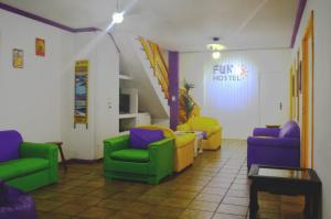 una sala de espera con sillas coloridas y una señal en Cabo Frio Fun Hostel, en Cabo Frío