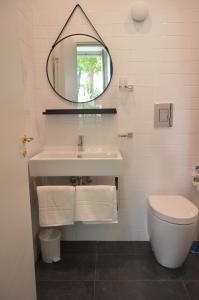 uma casa de banho com um lavatório, um WC e um espelho. em Casa Roger em Nápoles