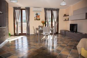 a living room with a dining room table and a television at Casa La Ferula apt3 vicino al mare e Taormina con terrazza panoramica in SantʼAlessio Siculo
