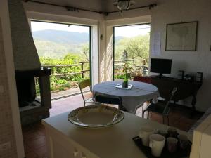 a kitchen with a table and a balcony with a view at Casa di Ester - villino con vista panoramica e giardino privato sulla collina di Porto Stefano - Monte Argentario - Vikey in Porto Santo Stefano