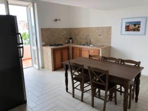 a kitchen with a wooden table and chairs and a kitchen with a refrigerator at Casa GARY in Ponza